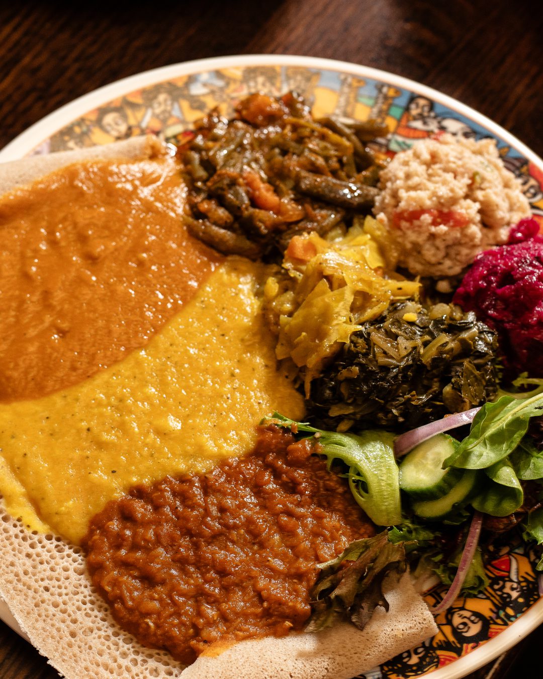 A vibrant feast: Includes Miser, Ater, Shiro, Gomen, Tikel Gomen, Fosolia, Tomato Fitfit, Beets and Potatoes. Served with fresh Injera.